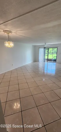 a view of a livingroom with an empty space and a window