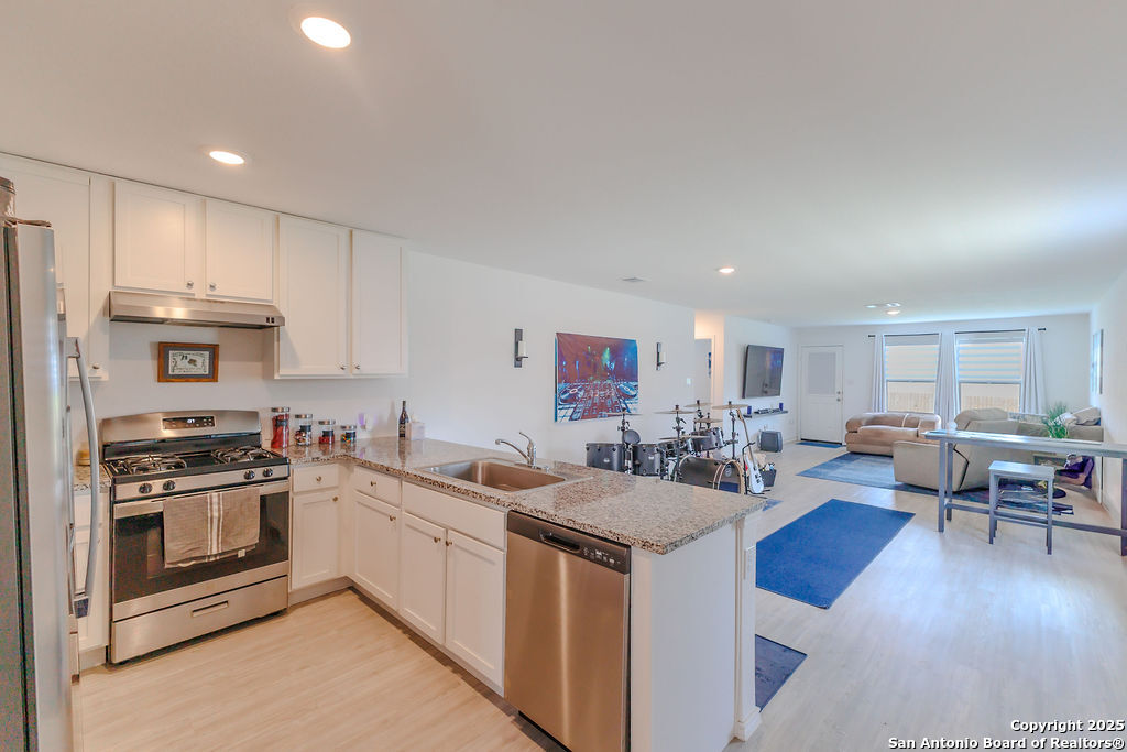 10502 Torroja Way Converse, TX 78109 - Photo 12 of 35 a kitchen with stainless steel appliances a stove a sink a oven a dining table and chairs