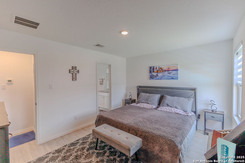 10502 Torroja Way Converse, TX 78109 - Photo 15 of 35 a bedroom with a bed and wooden floor