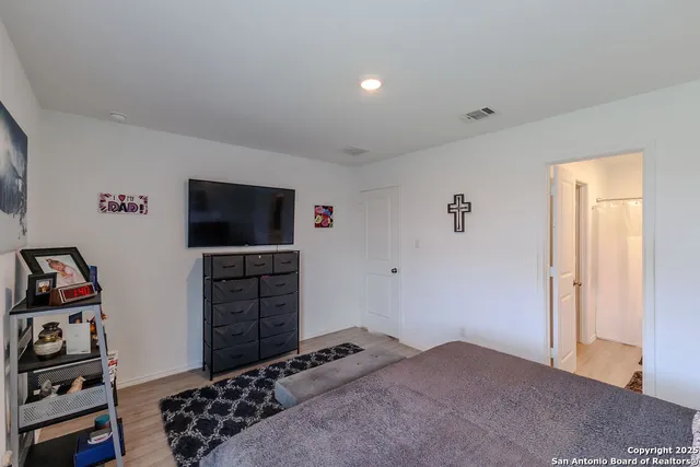 a bedroom with a bed and a flat screen tv