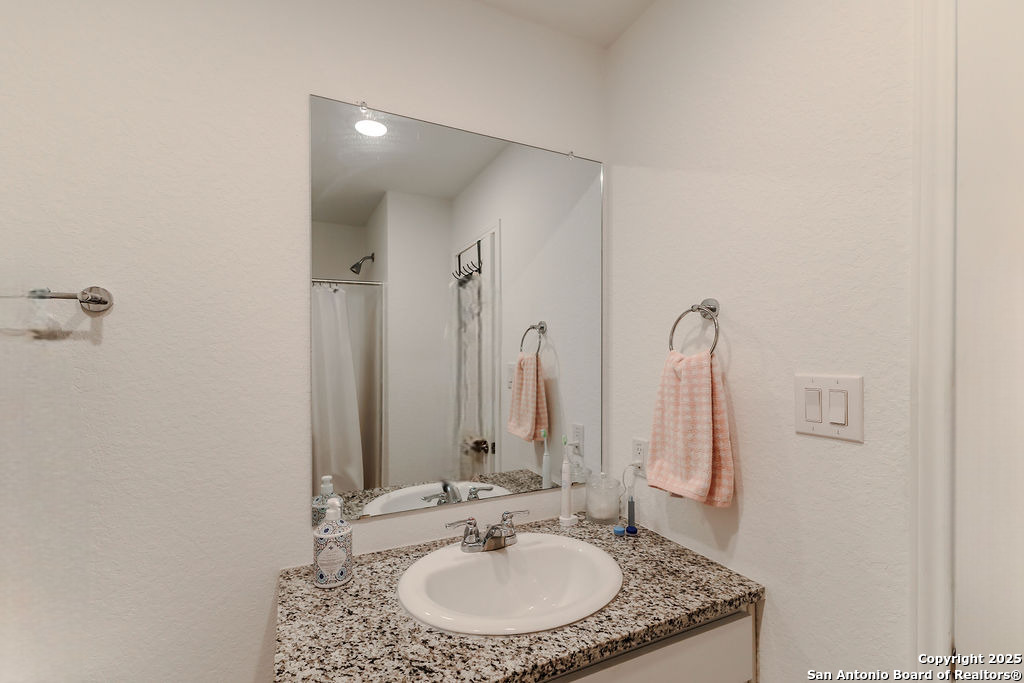 10502 Torroja Way Converse, TX 78109 - Photo 25 of 35 a bathroom with a granite countertop sink and a mirror