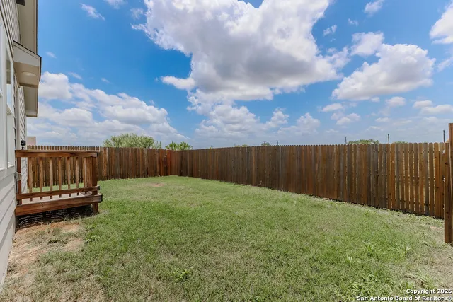 a view of a backyard with wooden fence