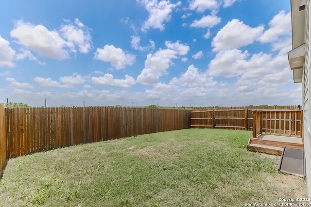 a view of a backyard with wooden fence