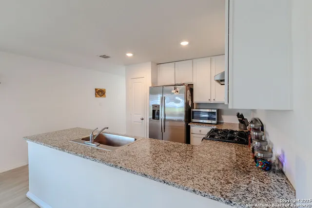a kitchen with a refrigerator and a sink
