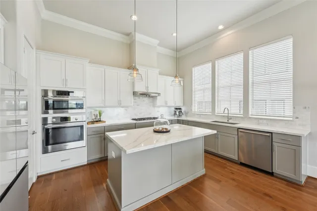 a kitchen with stainless steel appliances granite countertop a sink stove cabinets and refrigerator