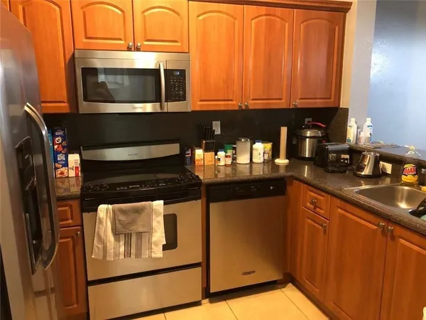 a kitchen with stainless steel appliances granite countertop a stove microwave and refrigerator