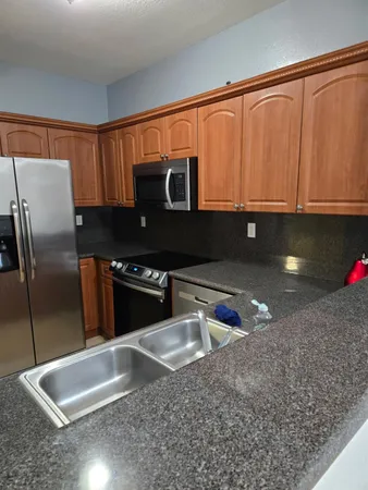 a kitchen with stainless steel appliances granite countertop a stove a sink and a microwave