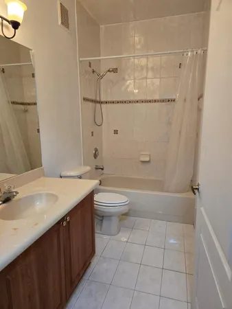 a bathroom with a granite countertop sink a toilet and shower