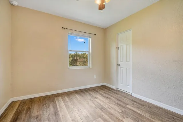 an empty room with a window and wooden floor