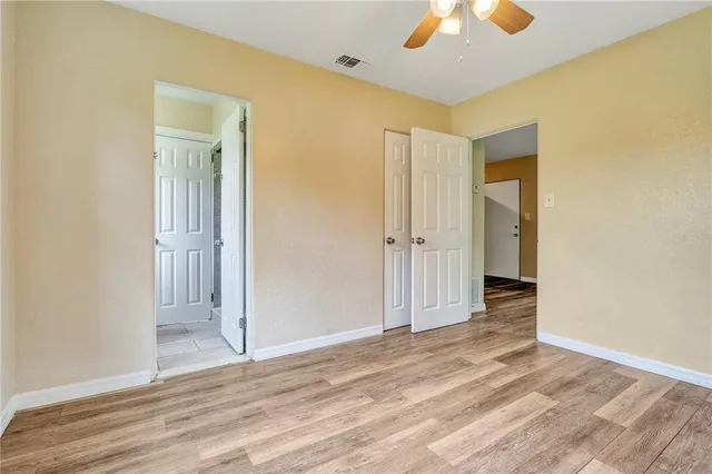 a view of a big room with wooden floor and a ceiling fan