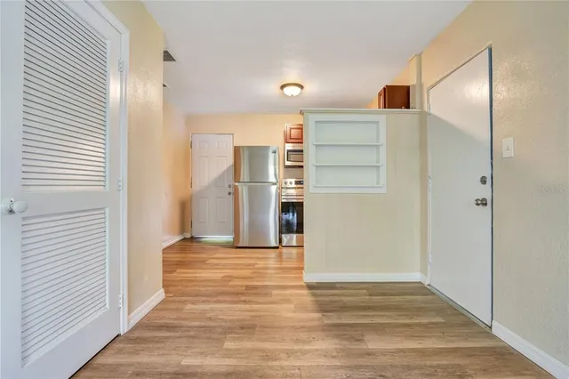 a view of a kitchen with wooden floor and a refrigerator
