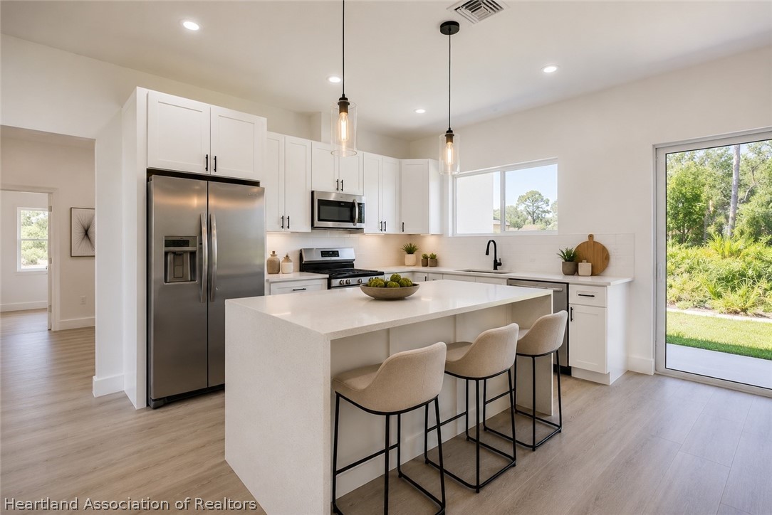 4307 Talbot Street Sebring, FL 33872 - Photo 5 of 19 a kitchen with kitchen island granite countertop a sink stove and refrigerator