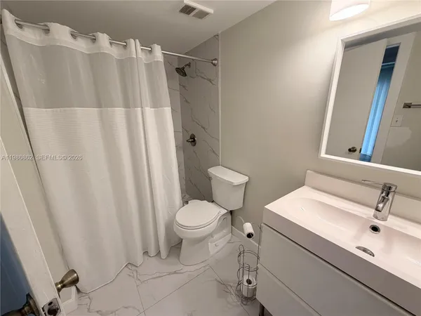 a bathroom with a sink toilet and shower