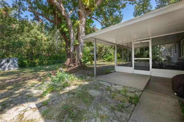 a view of a chair and table in backyard of the house