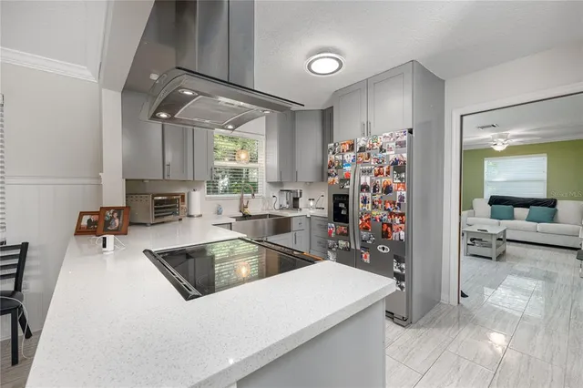 a view of a kitchen with a sink and dishwasher with a dining table chair