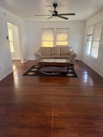 a living room with furniture flat screen tv and window