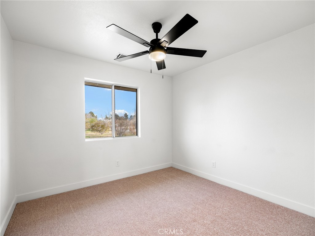 12780 Hacienda Road Phelan, CA 92371 - Photo 17 of 38 an empty room with window and a ceiling fan