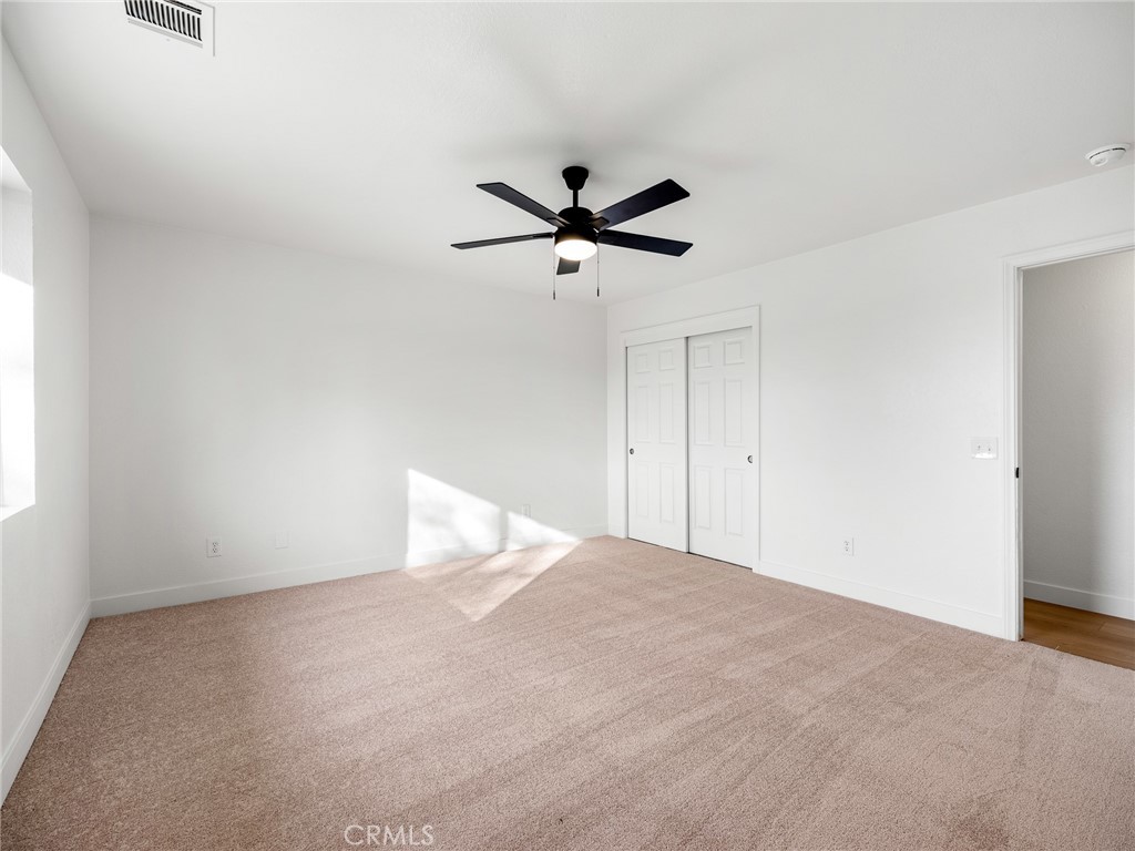 12780 Hacienda Road Phelan, CA 92371 - Photo 20 of 38 a view of a room with a ceiling fan and a window