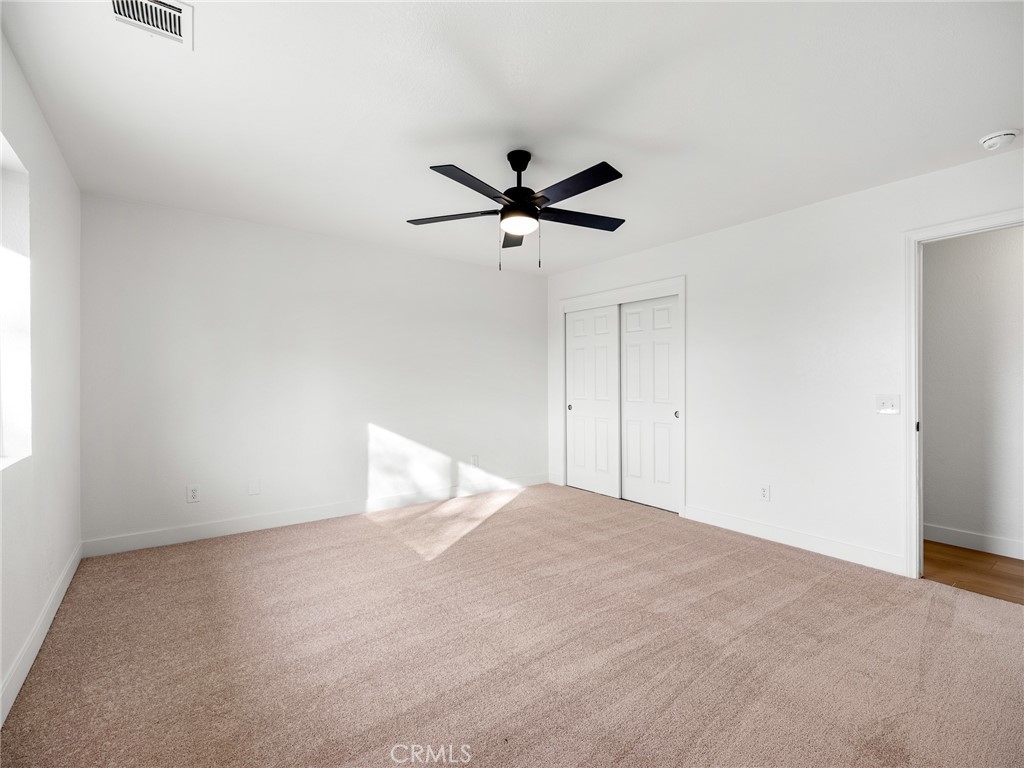 12780 Hacienda Road Phelan, CA 92371 - Photo 20 of 38 a view of a room with a ceiling fan and a window