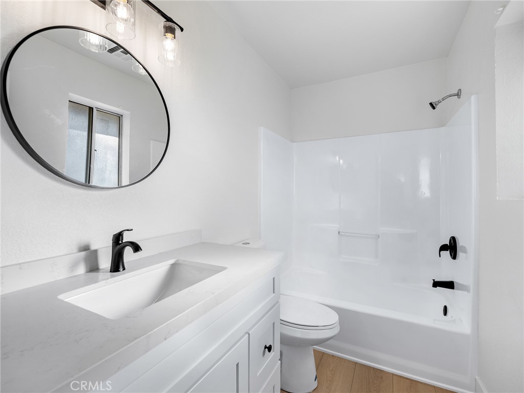 12780 Hacienda Road Phelan, CA 92371 - Photo 22 of 38 a bathroom with a sink a toilet and a mirror