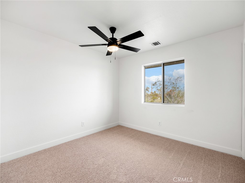 12780 Hacienda Road Phelan, CA 92371 - Photo 23 of 38 an empty room with windows and fan