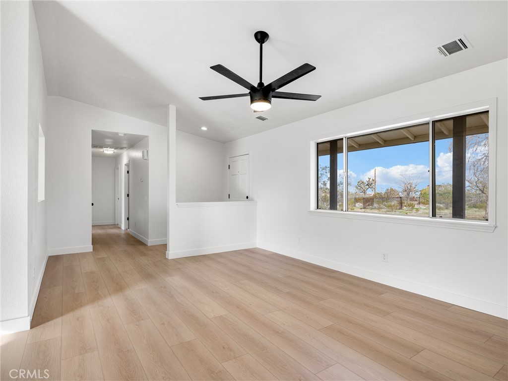 12780 Hacienda Road Phelan, CA 92371 - Photo 9 of 38 a view of a bedroom with wooden floor and a ceiling fan