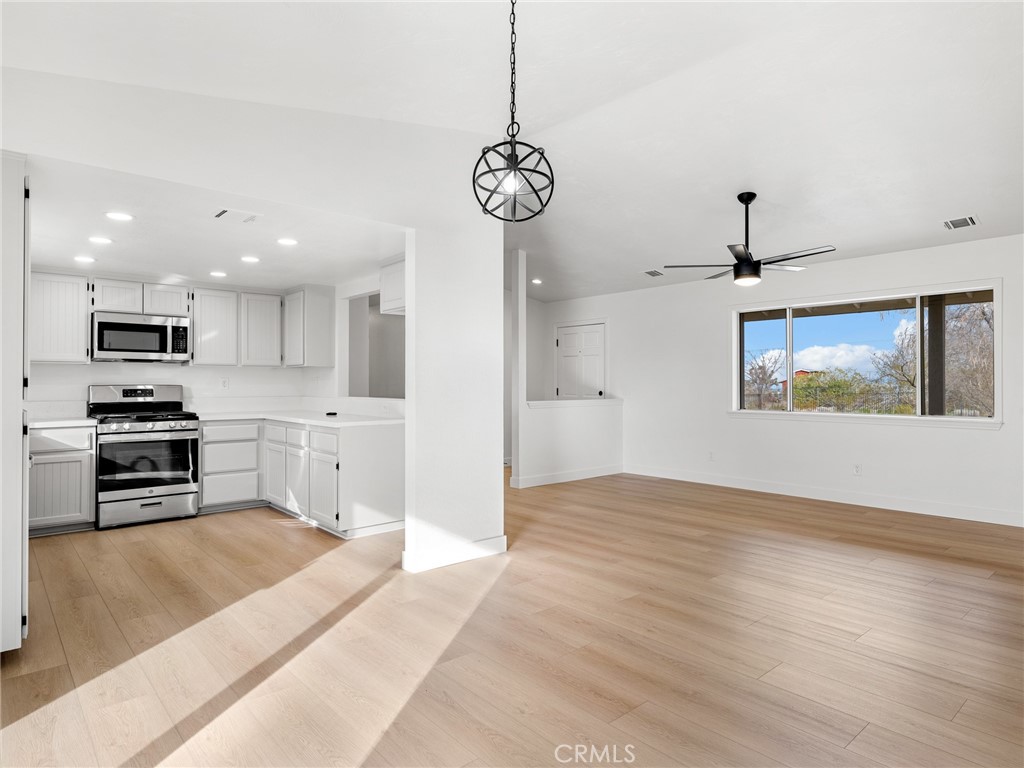 12780 Hacienda Road Phelan, CA 92371 - Photo 10 of 38 a view of kitchen with stainless steel appliances granite countertop cabinets and wooden floor