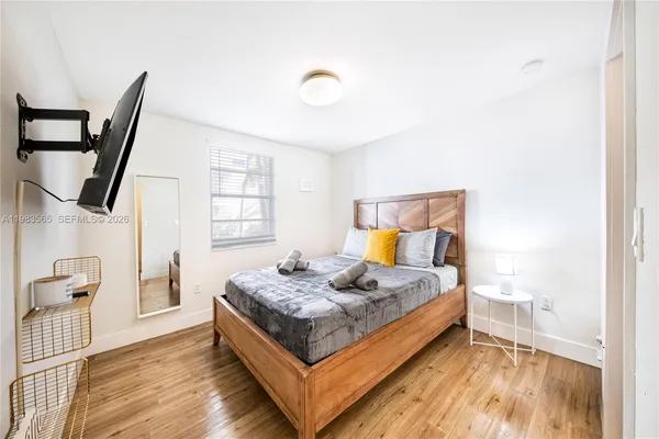 a spacious bedroom with a bed and wooden floor