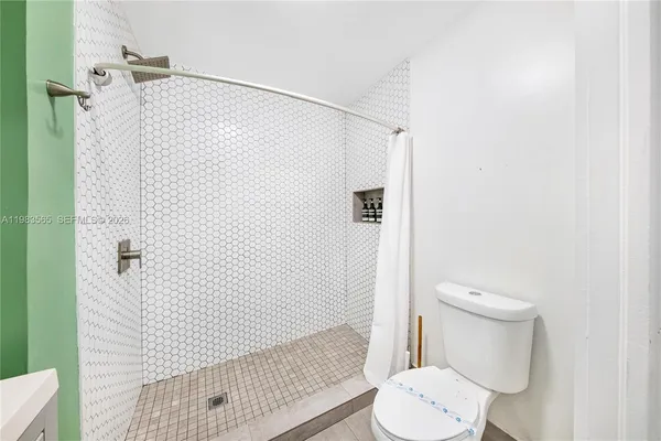 a bathroom with a toilet and a shower