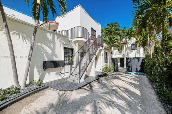 a view of a house with a small yard and a palm tree
