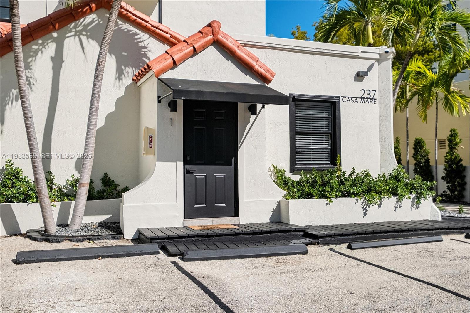 237 38th Street, Unit 4 Miami Beach, FL 33140 - Photo 26 of 28 a front view of a house with a yard and garage