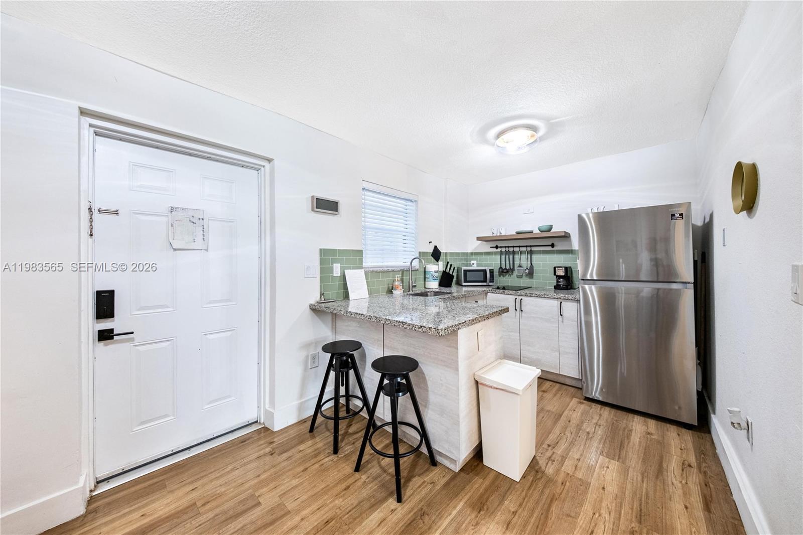 237 38th Street, Unit 4 Miami Beach, FL 33140 - Photo 6 of 28 a kitchen with a refrigerator a sink and cabinets