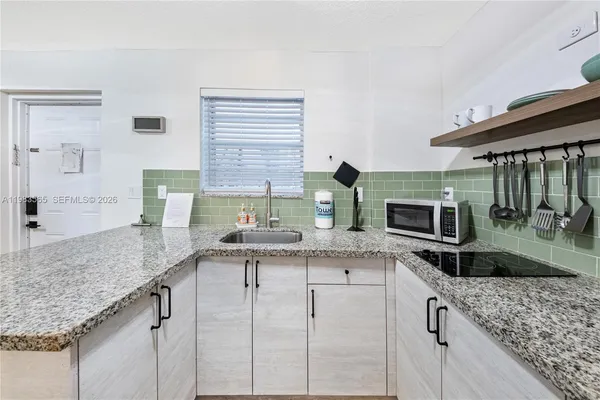 a kitchen with granite countertop a sink and a wooden cabinets