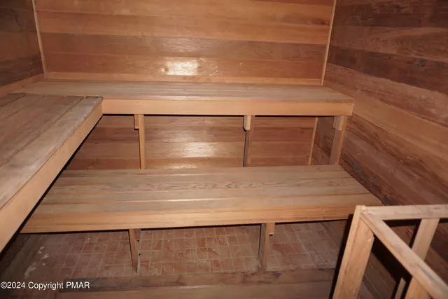 a large bedroom with a bed and wooden floor