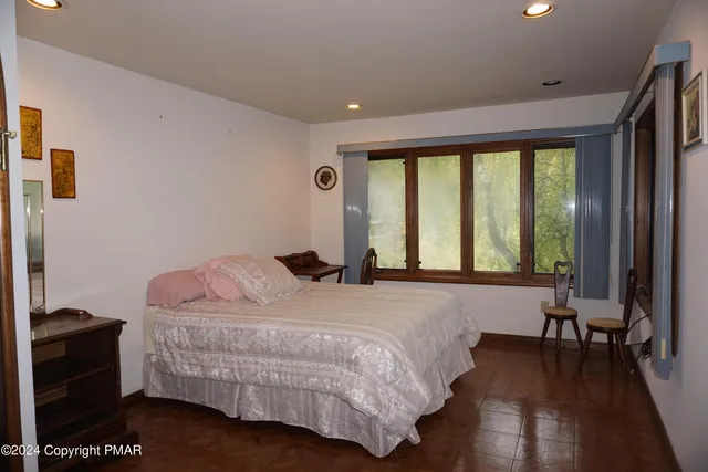 a bedroom with a bed and a large window