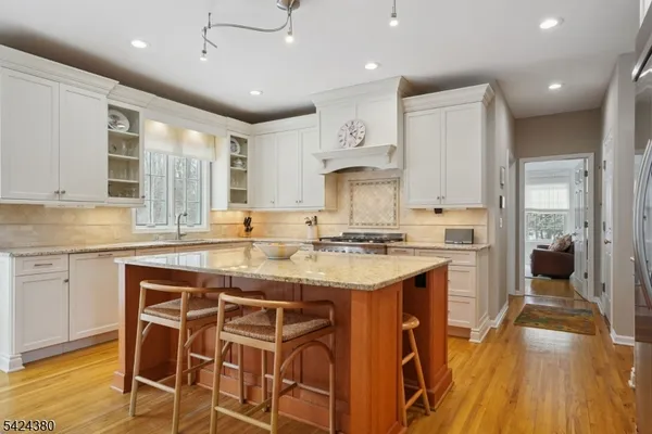 a kitchen with granite countertop a sink appliances cabinets and wooden floor