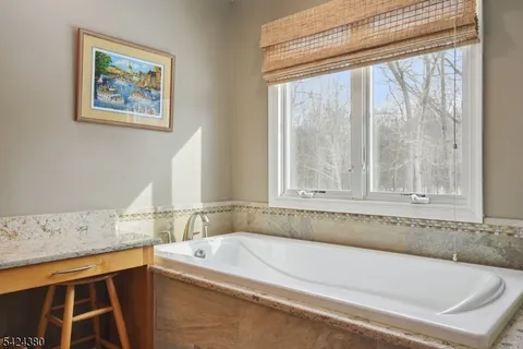a bedroom with a bed chandelier and a window