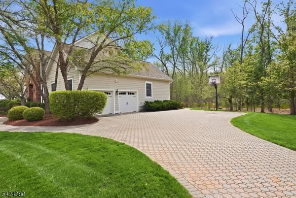 a view of a white house with a big yard and large trees