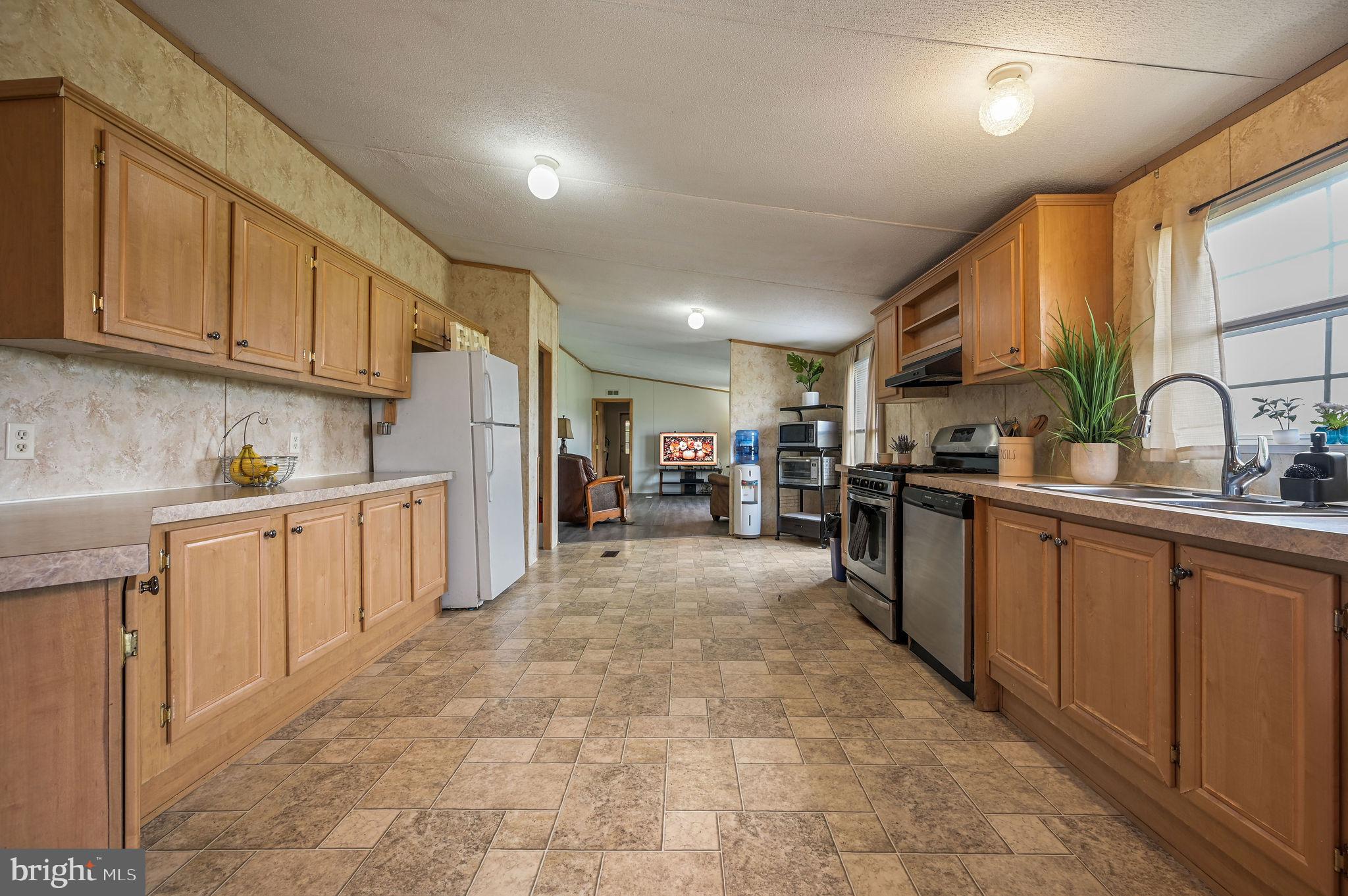 158 Caveat Road, Unit 200 Magnolia, DE 19962 - Photo 5 of 17 a kitchen with refrigerator and cabinets