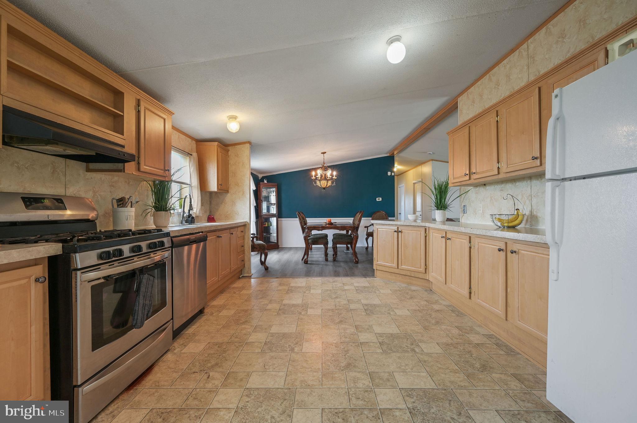 158 Caveat Road, Unit 200 Magnolia, DE 19962 - Photo 6 of 17 a kitchen with stainless steel appliances granite countertop a stove top oven a sink dishwasher and white cabinets