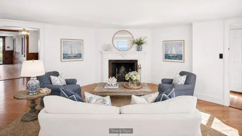 a living room with furniture a fireplace and a mirror