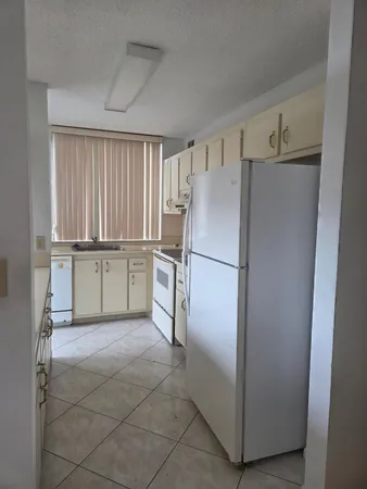 a kitchen with cabinets and refrigerator