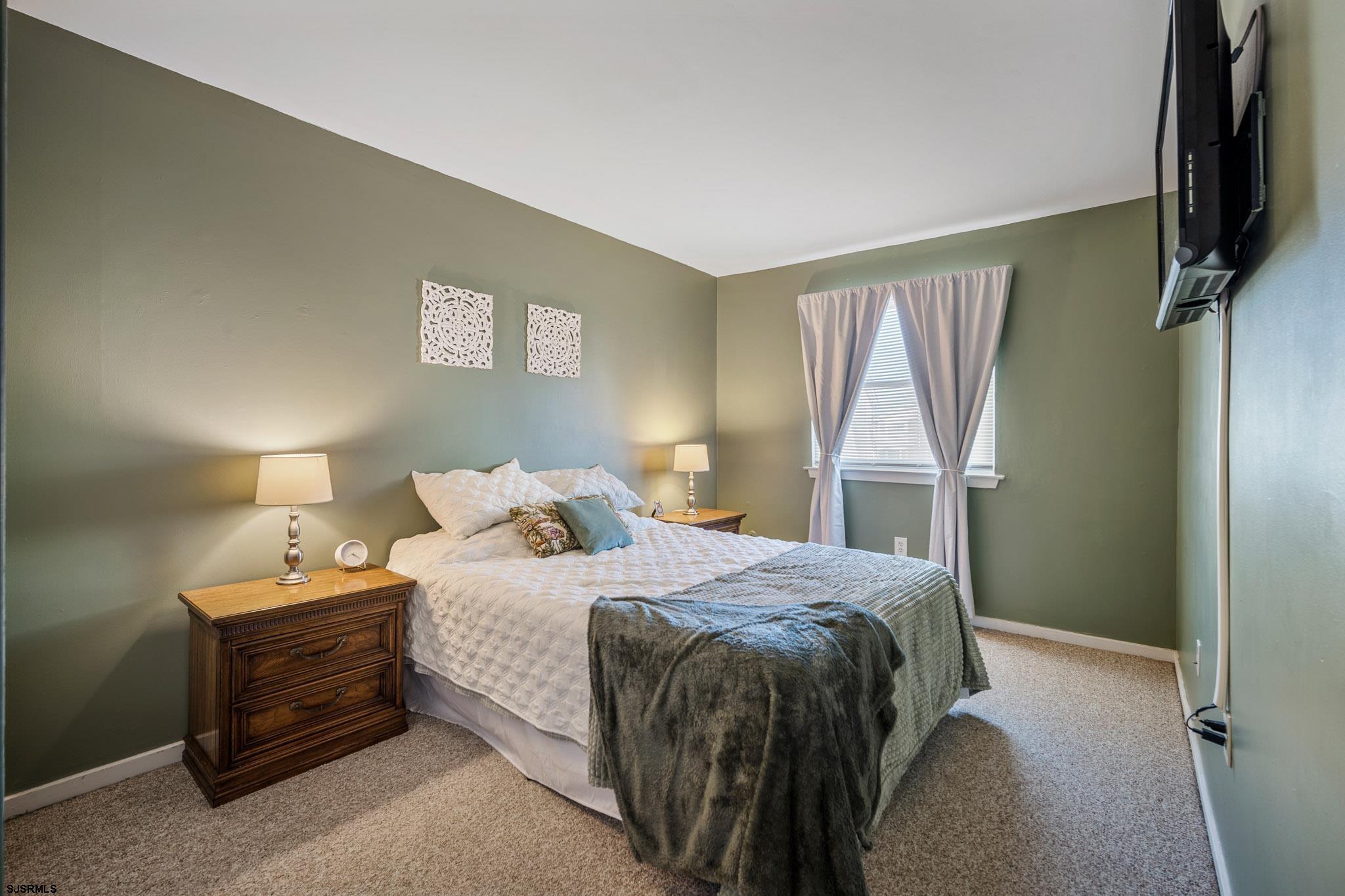 72 Delmar Drive Brigantine, NJ 08203 - Photo 20 of 29 a bedroom with a bed and a flat tv screen on a dresser