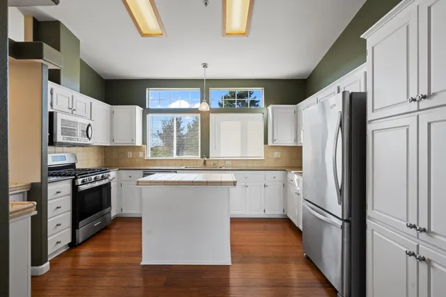 a kitchen with stainless steel appliances a refrigerator and a stove top oven