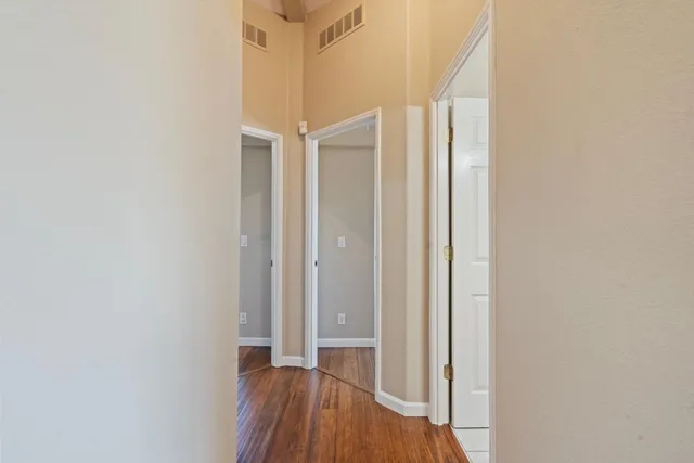 a view of a hallway with wooden floor and a window