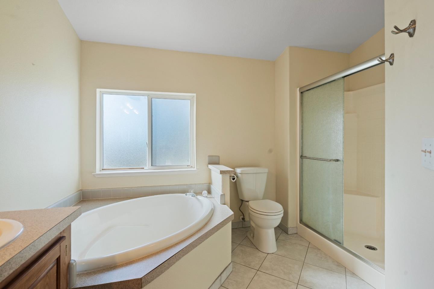 10114 Reese Circle Salinas, CA 93907 - Photo 30 of 43 a bathroom with a white bath tub a toilet and a shower