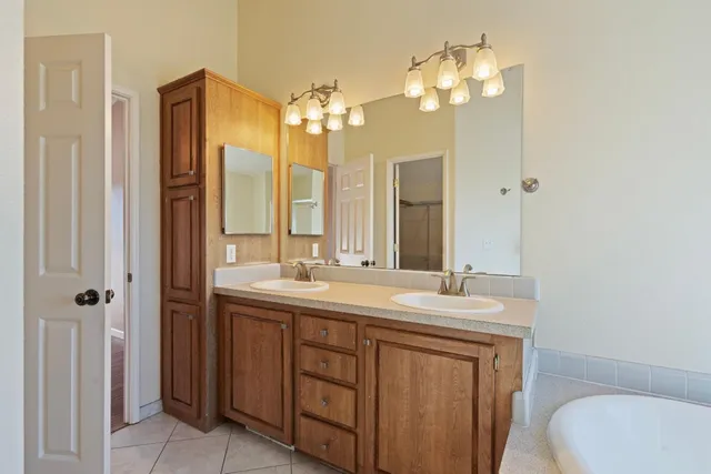 a bathroom with a double vanity sink mirror and toilet