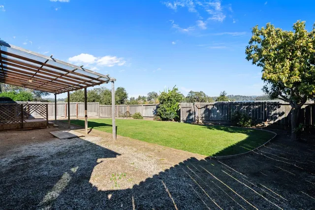 a view of a backyard with wooden fence