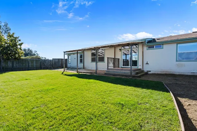 a view of a house with backyard and a patio