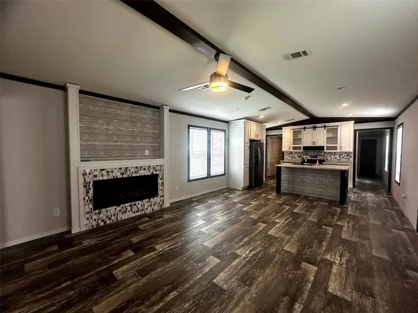 a living room with furniture kitchen view and a window